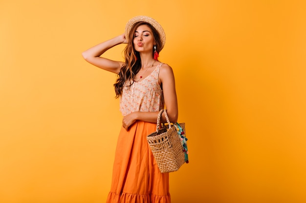 Vrolijke vrouw in zomer rok poseren met kussende gezichtsuitdrukking. Indoor portret van ontspannen elegante gember dame genieten van vrije tijd in de studio.