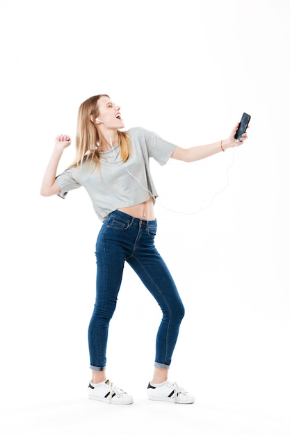 Vrolijke vrouw luisteren muziek en dansen