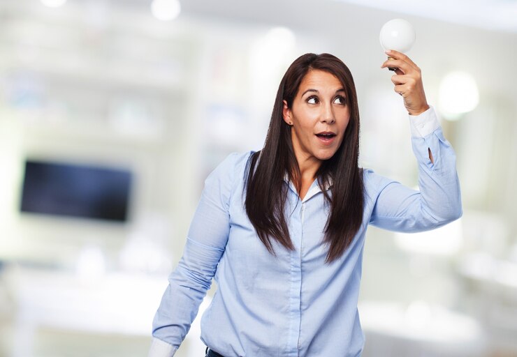 Gratis Foto vrolijke vrouw met een gloeilamp