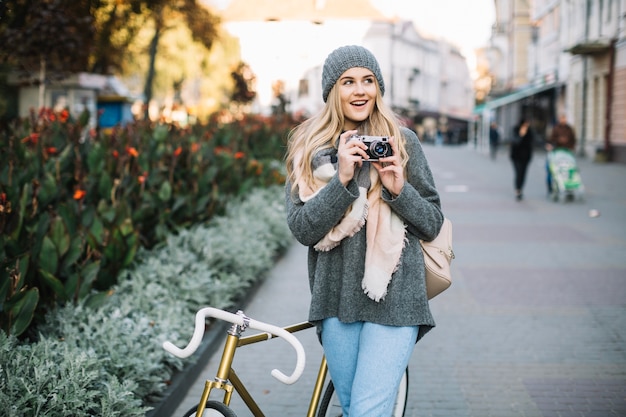 Vrolijke vrouw met fiets en camera