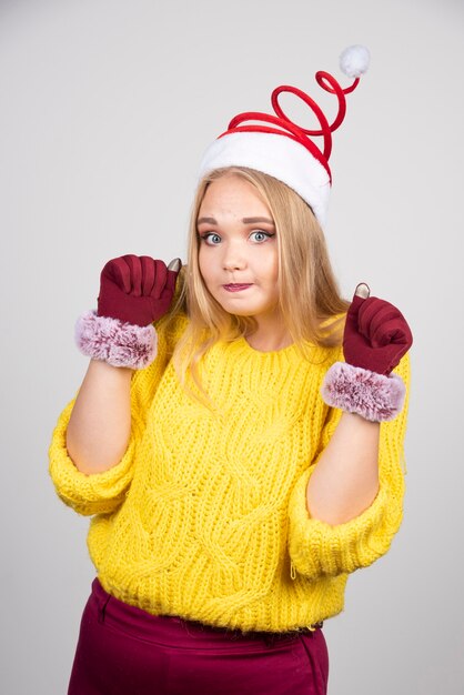 Vrolijke vrouw met gele trui en kerstmuts.