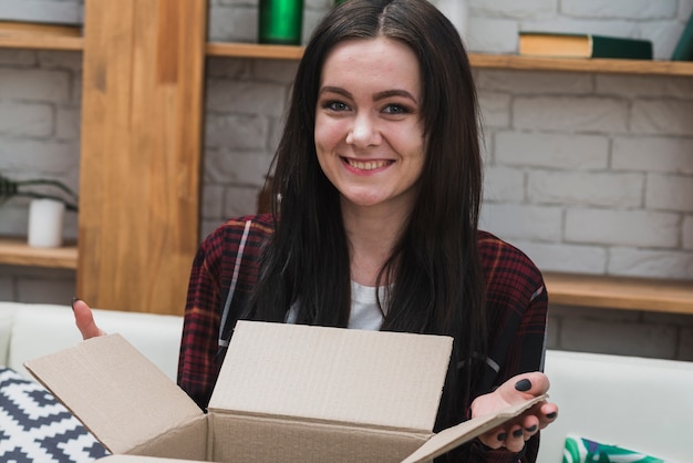 Vrolijke vrouw met geopend pakket