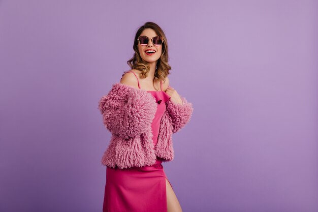 Vrolijke vrouw poseren in trendy roze jurk