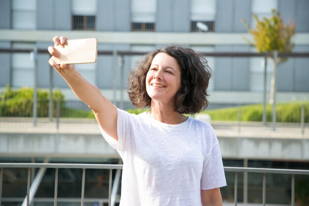 Vrolijke vrouwelijke toerist die selfie nemen