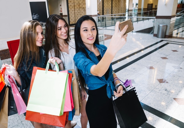 Vrolijke vrouwen poseren voor selfie in winkelcentrum