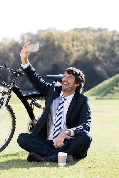 Vrolijke zakenman die selfie buitenshuis