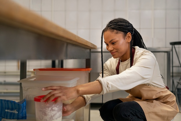 Gratis foto vrouw aan het werk in keuken zijaanzicht