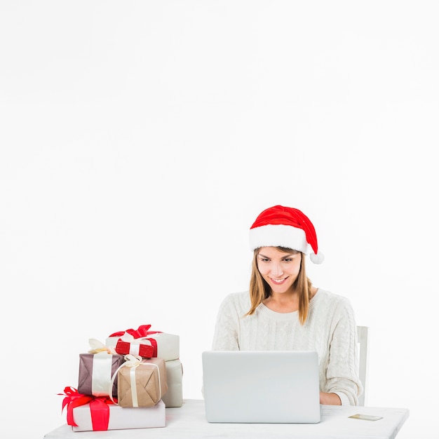 Vrouw aan tafel met laptop en creditcard