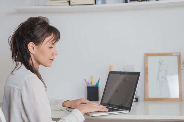 Vrouw aan tafel met laptop