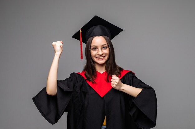 Vrouw afgestudeerde student dragen afstuderen hoed en toga, geïsoleerd op wit