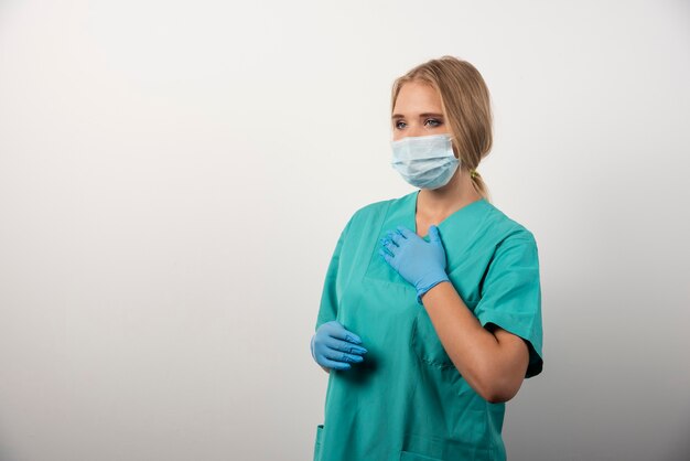 Vrouw arts met latex handschoenen en medisch masker.
