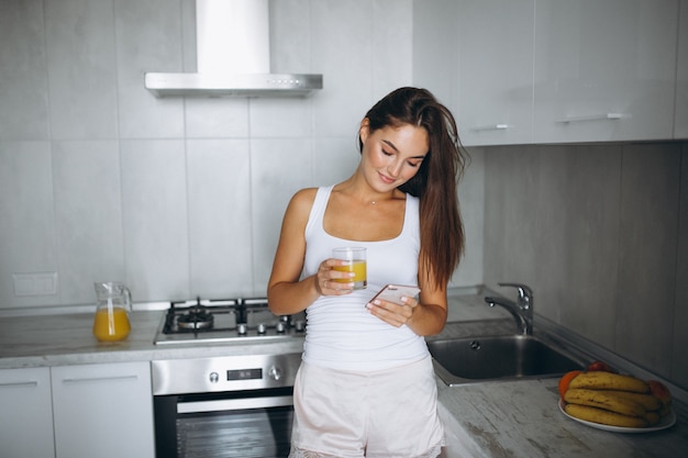 Vrouw bij haar keuken het drinken sap