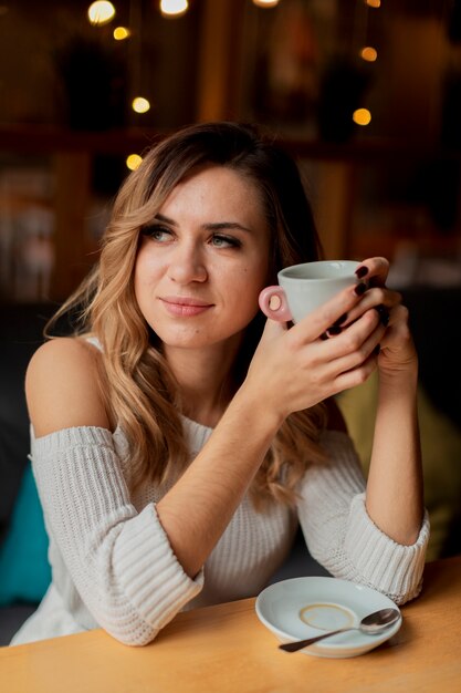 Vrouw bij restaurant koffie drinken