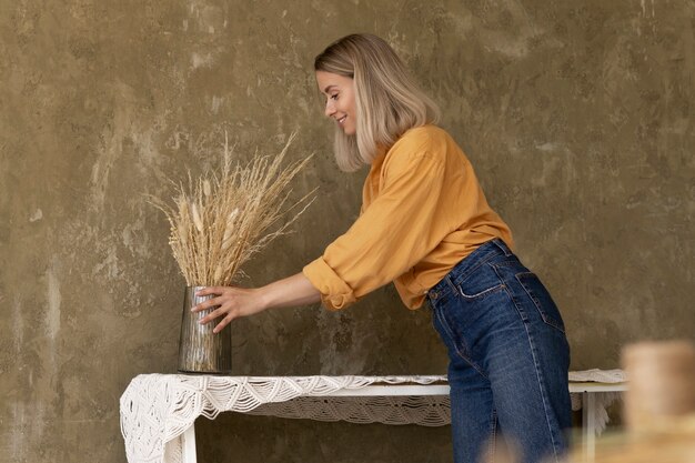 Vrouw bouwt haar eigen droogbloemenarrangement