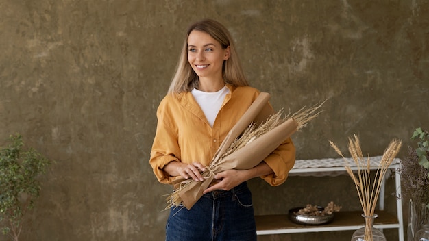 Gratis foto vrouw bouwt haar eigen droogbloemenarrangement