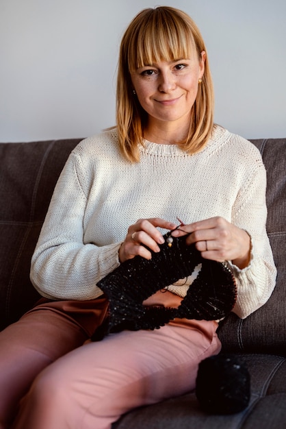 Gratis foto vrouw breien een zwarte draad accessoire vooraanzicht