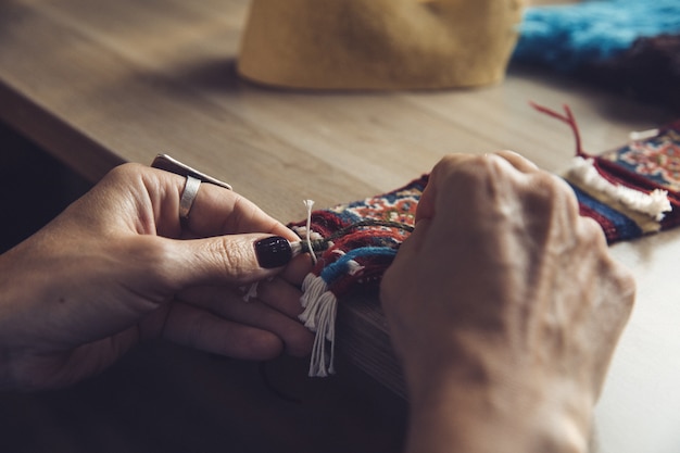 Gratis foto vrouw breien tapijt met oosterse versieringen