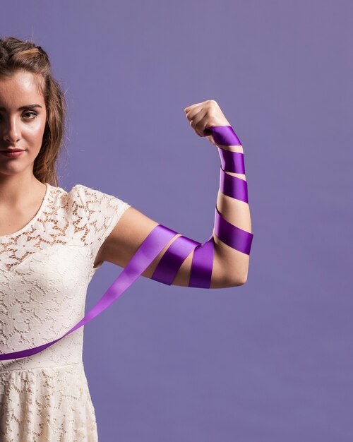 Vrouw buigt haar arm met lint ter ondersteuning van het feminisme