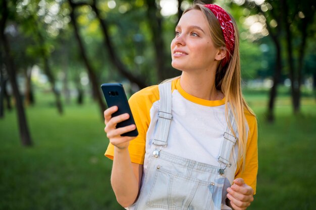 Gratis foto vrouw buitenshuis met smartphone