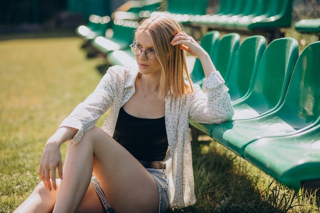 Vrouw cheerleader zittend op het voetbalveld