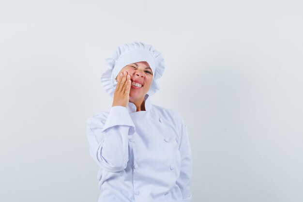 vrouw chef-kok in wit uniform met kiespijn en ongemakkelijk op zoek