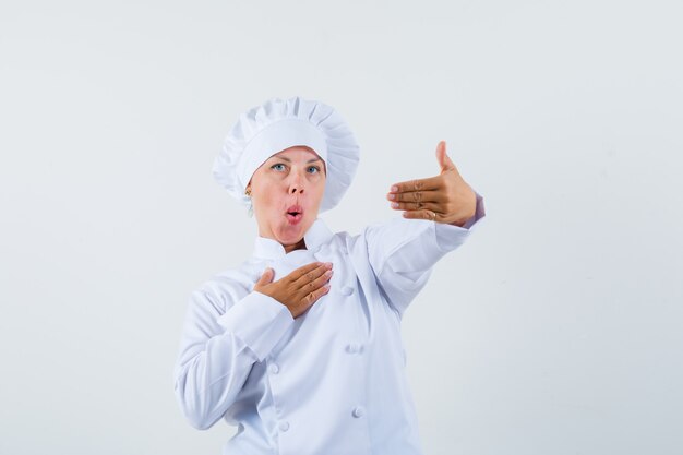 vrouw chef-kok poseren als zoeklijst in wit uniform en op zoek gericht
