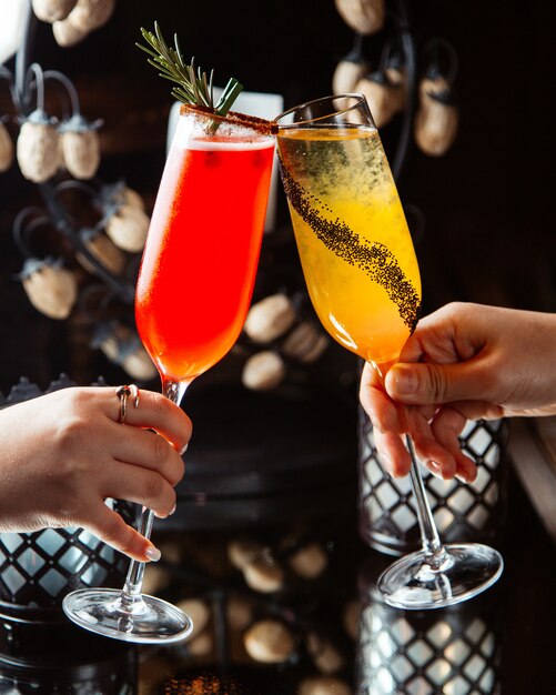 Vrouw clink champagneglazen met citrus cocktails