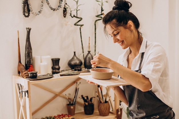 Gratis foto vrouw craftmaster bij een aardewerkwinkel