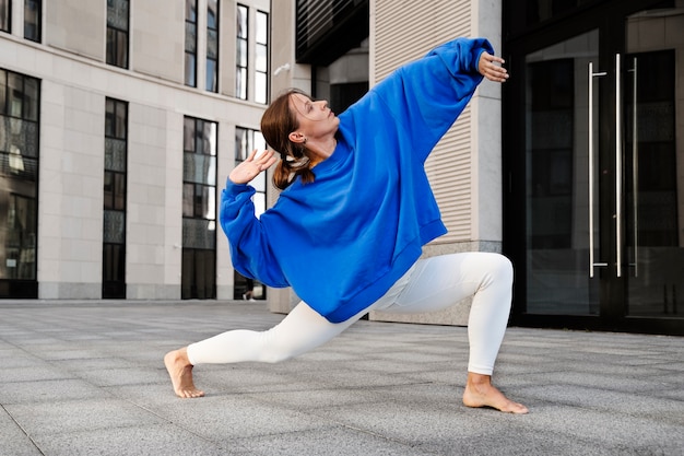 Gratis foto vrouw dansen in de stad volledig schot