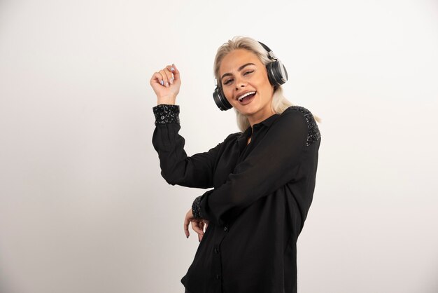 Vrouw dansen met ritme van muziek op witte achtergrond. Hoge kwaliteit foto