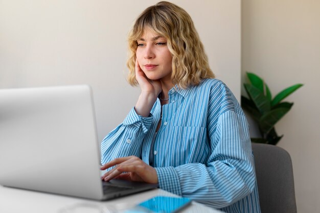 Vrouw die aan laptop zijaanzicht werkt