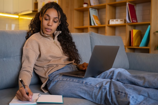 Gratis foto vrouw die aan laptop zijaanzicht werkt