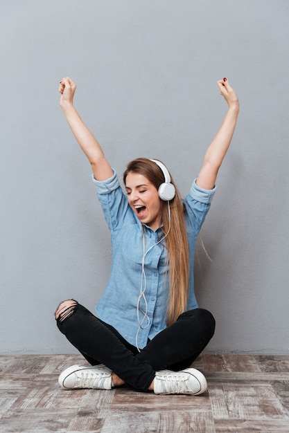 Vrouw die aan muziek op de vloer luistert