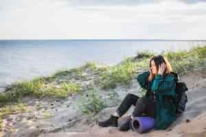 Gratis foto vrouw die aan muziek op strand luistert