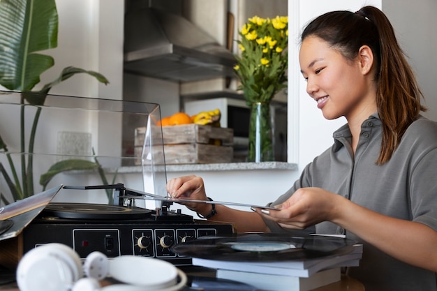 Gratis foto vrouw die aan muziek thuis luistert