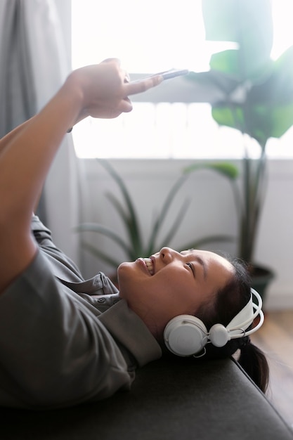 Vrouw die aan muziek thuis luistert