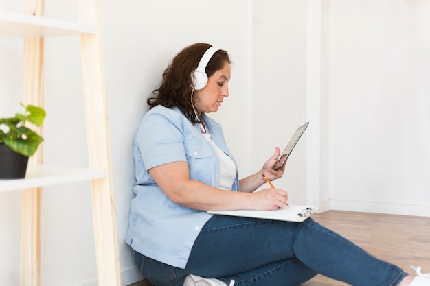 Gratis foto vrouw die aan tablet van huis werkt