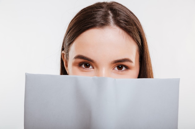 Vrouw die achter het boek kijkt