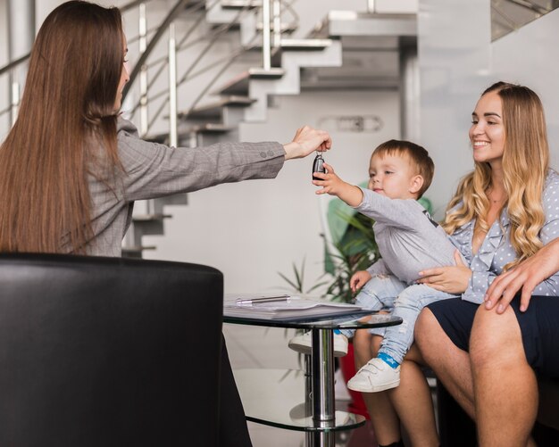 Vrouw die autosleutels geeft aan een baby