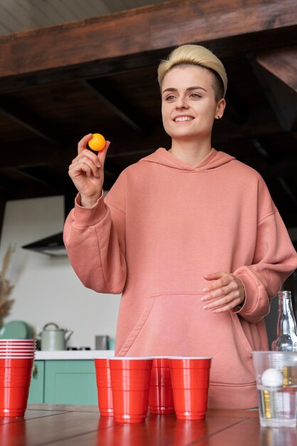 Vrouw die bierpong speelt op een binnenfeest