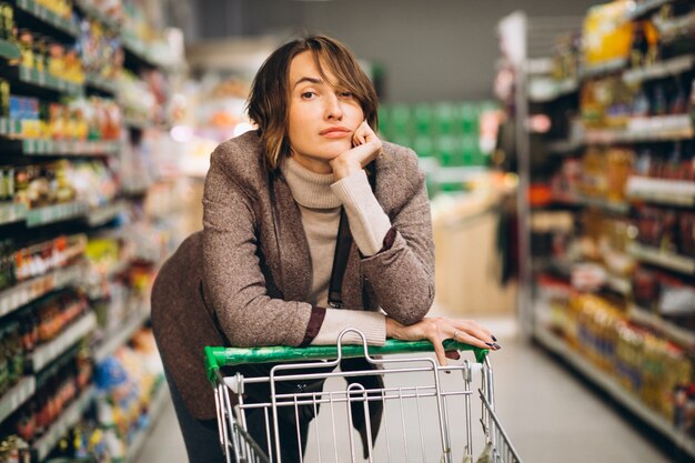 Vrouw die bij de supermarkt winkelt