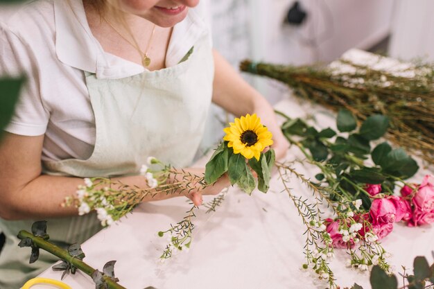 Vrouw die bloemen samen in boeket samenstellen