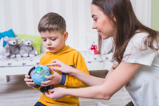 Vrouw die bol tonen aan zoon