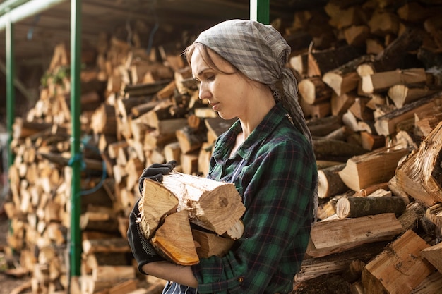 Vrouw die brandhout draagt