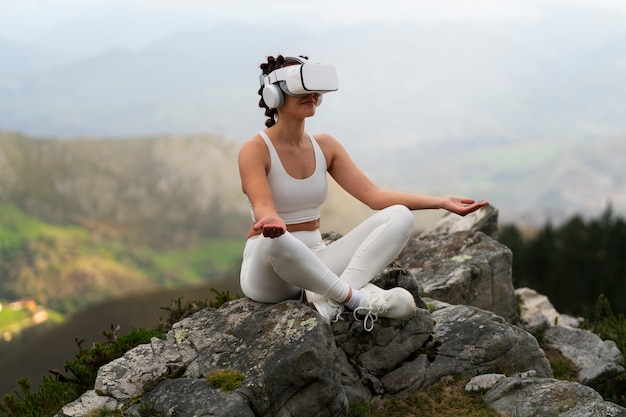 Gratis foto vrouw die buiten in de natuur traint met een vr-bril