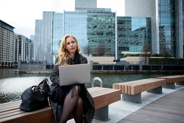 Vrouw die buitenshuis werkt met een laptop