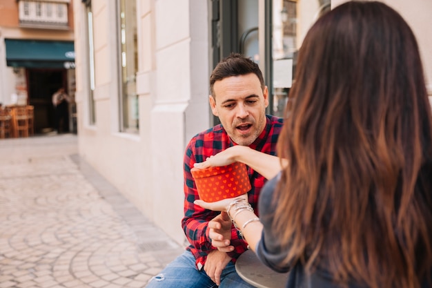 Vrouw die cadeau doos toont aan een vriendje