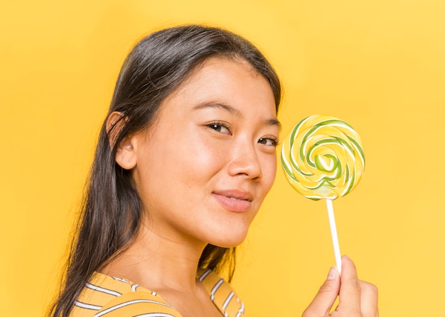 Vrouw die camera bekijkt en een lolly toont