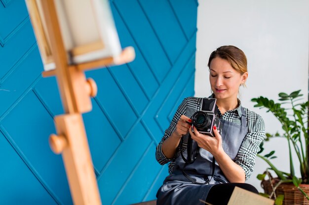 Gratis foto vrouw die canvas op schildersezel fotograferen