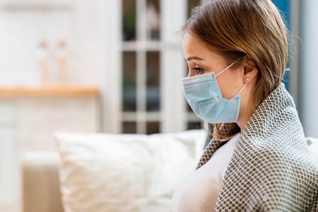 Vrouw die chirurgisch gezichtsmasker binnen draagt